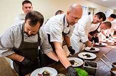 Chefs prepare a meal at Gourmet and Grapes